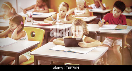 Les enfants de l'école studying in classroom Banque D'Images