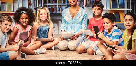 Avec les enfants d'enseignants holding digital tablets Banque D'Images