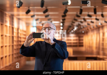 21 mars 2019, Berlin : l'architecte britannique David Chipperfield prend une photo de l'invités avec son smartphone à un rendez-vous pour visiter la galerie James Simon. À partir de l'été prochain, la galerie sera l'entrée de l'île aux musées de Berlin. Photo : Monika Skolimowska/dpa-Zentralbild/dpa Banque D'Images