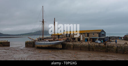 Lyme Regis, dans le Dorset, UK. 21 mars 2019. Navire à voile traditionnelle 1907 'Irene' amarré à Lyme Regis port comme le 100 pied ketch et le Cobb historique bâtiments sont transformés en un décor de cinéma en état de disponibilité pour continué le tournage de Ammonite avec Kate Winslet et Saoirse Ronan. Réalisé par Francis Lee, la fiction dramatique dépeint célèbre chasseur de fossiles que Mary Anning femme gay suscitant des débats entre les historiens et sur les médias sociaux. Le film est prévu d'apporter un coup de pouce pour le tourisme et l'économie locale. Credit : Celia McMahon/Alamy Live News Banque D'Images