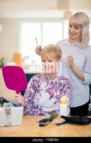 Coiffure Mobile féminin senior coupe de cheveux à la maison de womans Banque D'Images