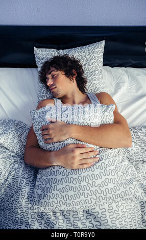 Man sleeping in bed at home Banque D'Images