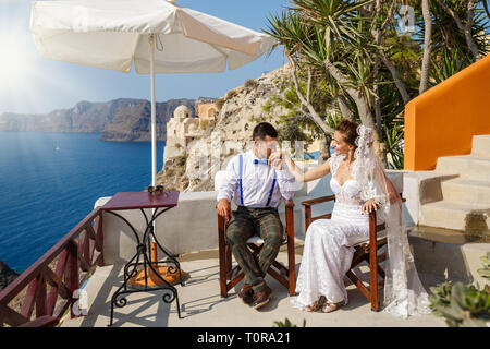 Mariage, le marié embrasse la main de la mariée sur l'arrière-plan de la mer paysage Banque D'Images