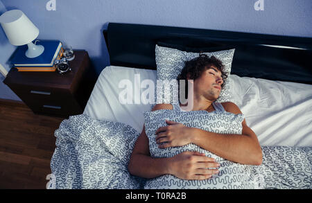 Man sleeping in bed at home Banque D'Images