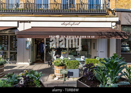 Une femme avec son chien à l'extérieur de Daylesford Organic food shop sur Pimlico Road, Belgravia, Londres, Royaume-Uni Banque D'Images