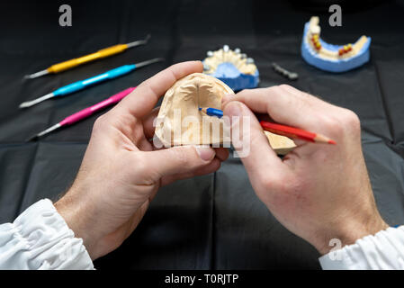 Technicien dentaire ou un dentiste travaillant avec des prothèses de dents dans son laboratoire Banque D'Images
