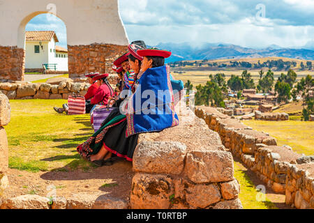 Un groupe de femmes autochtones Quechua péruvien assis sur un ancien mur Inca dans la ruine Inca archéologique de Chinchero, province de Cusco, Pérou. Banque D'Images