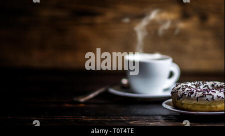 Saupoudrer de chocolat blanc avec anneau et tasse de café sur la table en bois Banque D'Images