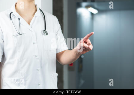 Bright close up of male doctor in uniform with stethoscope doigt en l'air. L'espace de copie ou de l'espace graphique Banque D'Images