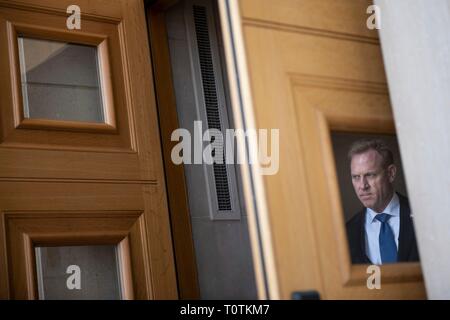 États-unis le secrétaire américain de la Défense par intérim Patrick Shanahan peaks out à partir de la porte d'entrée fenêtre car il attend que l'arrivée de M. Donald Trump au Pentagone le 15 mars 2019 à Washington, D.C. Banque D'Images