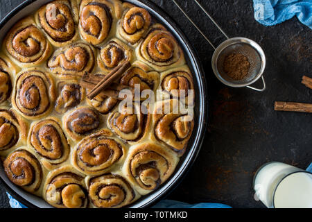 Tarte à la cannelle avec du sirop de sucre dans la casserole de vintage sur fond noir Banque D'Images