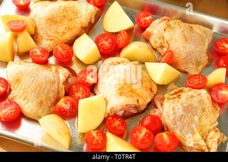 Frais généraux de dîner de poulet avec des pommes de terre et tomates cerises prêtes pour le four Banque D'Images