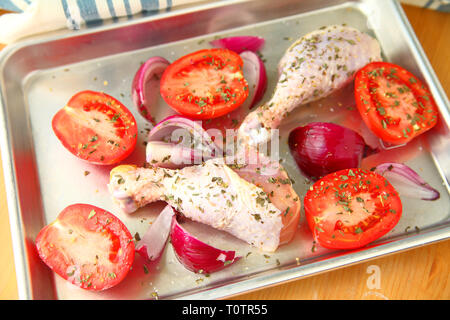 Des frais généraux pour une assiette de poulet avec les tomates Roma et oignons rouges Banque D'Images