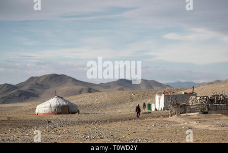 Bayan Ulgii, Mongolie, 30 Septembre 2015 : nomade kazakh mongol accueil dans un paysage de l'ouest de la Mongolie, femme marche devant sa maison Banque D'Images