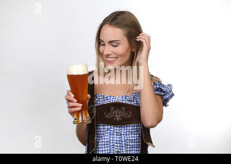 Très jolie jeune femme dans un dirndl avec une bière touche ses cheveux Banque D'Images