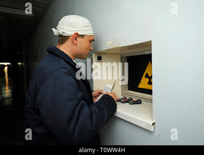 Travailleur debout devant une fenêtre du poste de contrôle de rayonnement à un passage de la centrale nucléaire de Tchernobyl. Avril 20,2018. Tchernobyl, Ukraine Banque D'Images