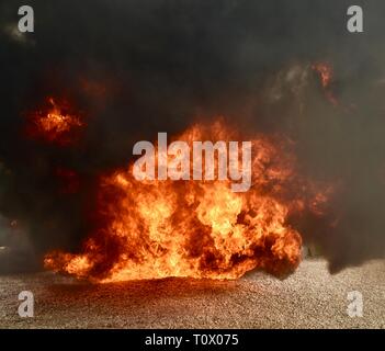 Dangereux, explosif Inferno fire avec, flammes et fumée noircit et tourbillonnent cloud et panaches de fumée. Banque D'Images