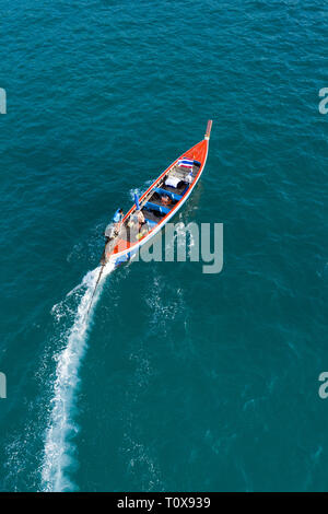 Vue de dessus, vue aérienne d'une belle longue queue bateau qui navigue sur une mer bleue laissant derrière eux un long service de l'eau. Phuket, Thailande. Banque D'Images