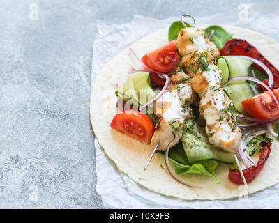 Sur des brochettes de poulet grillées avec sauce metal grec et des légumes frais sur le pain pita. La cuisine grecque. Banque D'Images