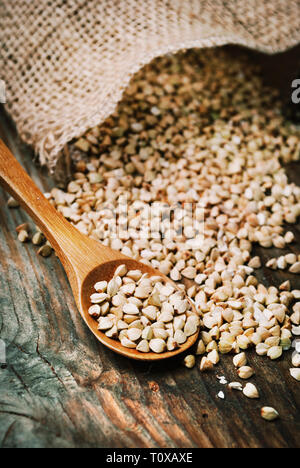 La vie toujours avec des grains de sarrasin heap dans cuillère en bois sur la table en bois vintage background. Une cuisine saine alimentation biologique. Sarrasin sans gluten Vegan Banque D'Images