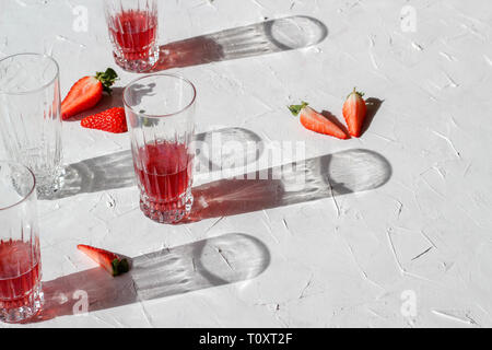 Ombre chinoise de les verres et les fraises sur fond blanc Banque D'Images