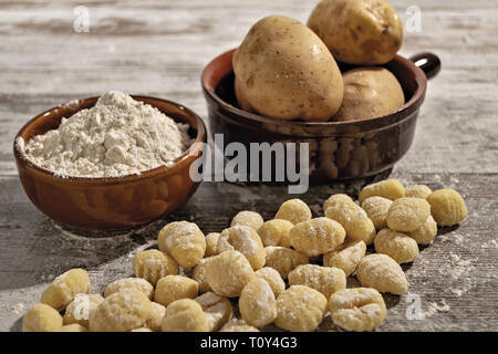 Gnocchi di patate su tavolo rustico con farina e patate da sopra Banque D'Images