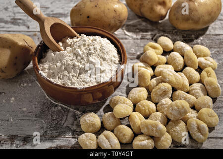Gnocchi di patate su tavolo rustico con farina e patate dall'alto Banque D'Images