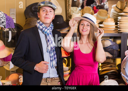 La femme et l'homme d'essayer sur la mode chapeaux dans le shopping mall Banque D'Images