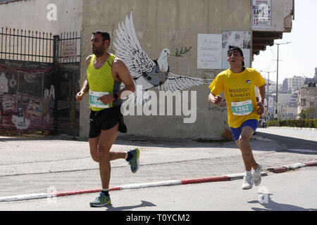 Bethléem, Cisjordanie, territoire palestinien. Mar 22, 2019. Activsts palestiniens et étrangers prennent part à la Palestine Marathon, dans la ville cisjordanienne de Bethléem, le vendredi 22 mars 2019. La Palestine septième international marathon a débuté ce matin à Bethléem avec la participation de 8000 coureurs venus de 76 pays, avec un 51,7 pour cent des femmes participants, selon les organisateurs du marathon : Crédit Hashlamoun Wisam APA/Images/ZUMA/Alamy Fil Live News Banque D'Images