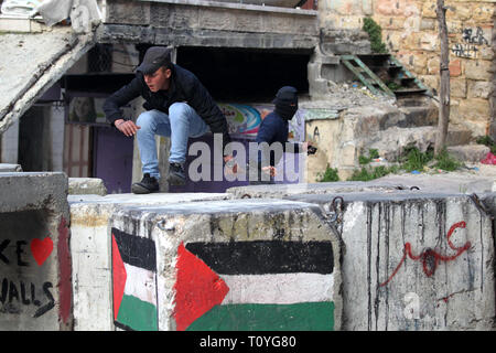 Hébron, en Cisjordanie, en territoire palestinien. Mar 22, 2019. Un manifestant palestinien jette une pierre vers les forces de sécurité israéliennes au cours d'affrontements dans la ville de Cisjordanie d'Hébron, le 22 mars 2019 Credit : Hashlamoun Wisam APA/Images/ZUMA/Alamy Fil Live News Banque D'Images