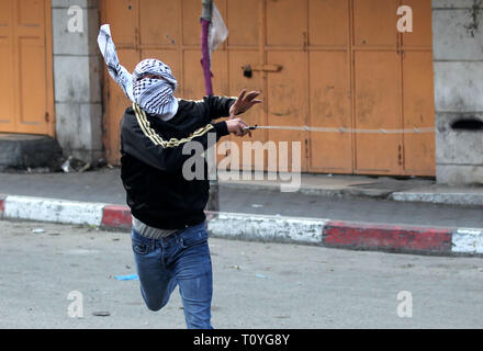 Hébron, en Cisjordanie, en territoire palestinien. Mar 22, 2019. Un manifestant palestinien jette une pierre vers les forces de sécurité israéliennes au cours d'affrontements dans la ville de Cisjordanie d'Hébron, le 22 mars 2019 Credit : Hashlamoun Wisam APA/Images/ZUMA/Alamy Fil Live News Banque D'Images