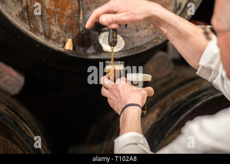 Malaga, Espagne - 2 mars, 2019 : Serveur puoring Malaga doux vin de canon. Ancienne taverne à vins traditionnels. Banque D'Images