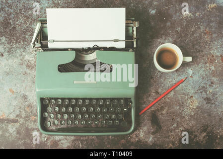 Vieille machine à écrire à côté d'une tasse de café contre Grunge background Banque D'Images
