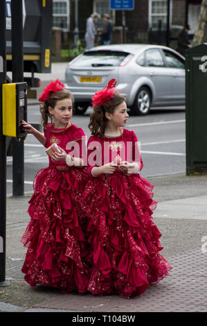 Deux filles juive hassidique dans glamour robes rouges robe pour Pourim le 21 mars 2019 sur un coin de rue à Stamford Hill Banque D'Images