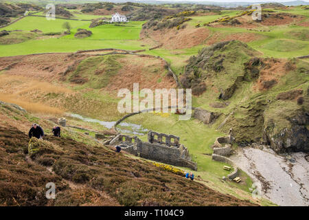 Les marcheurs marchent sur le sentier côtier escarpé depuis les anciennes œuvres de Porcelein à Porth Llanlleiana. Cemaes, Île d'Anglesey, pays de Galles, Royaume-Uni, Grande-Bretagne Banque D'Images