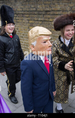 Garçon marchant en masque de Donald Trump et veste de costume pour la fête juive de Pourim à Stamford Hill, Londres 21 mars 2019, Banque D'Images