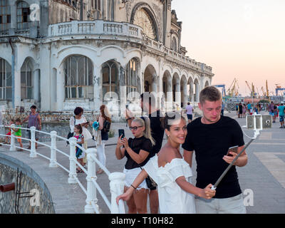 Une femme prend un bâton selfies avec elle à l'extérieur du casino à l'abandon à Constanta. Banque D'Images