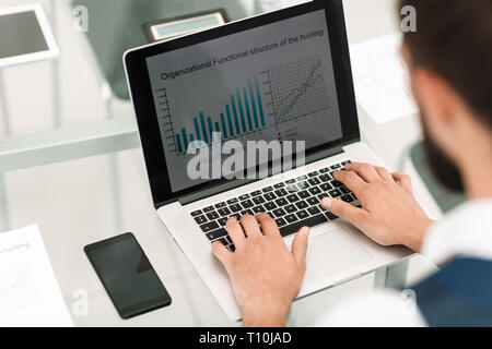 Close up.un homme utilise un ordinateur portable pour travailler avec les données financières Banque D'Images