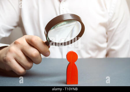 Businessman examine un homme rouge à travers une loupe. Vous pouvez chercher employé fiable. Maillon Faible. Diagnostic des maladies physiques et psychologiques Banque D'Images