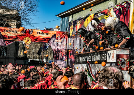 Faits saillants de la bataille de l'Orange, à Ivrea, près de Turin, en Italie, où les flammes orange sur le terrain l'attaque aux lanceurs d'orange qui defende eux-mêmes sur le chariot, et des courses d'orange Banque D'Images