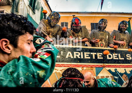 Faits saillants de la bataille de l'Orange, à Ivrea, près de Turin, en Italie, où les flammes orange sur le terrain l'attaque aux lanceurs d'orange qui defende eux-mêmes sur le chariot, et des courses d'orange Banque D'Images