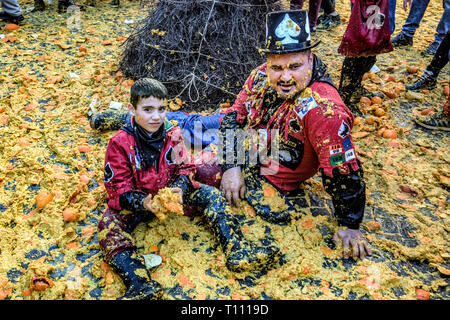 Faits saillants de la bataille de l'Orange, à Ivrea, près de Turin, en Italie, où les flammes orange sur le terrain l'attaque aux lanceurs d'orange qui defende eux-mêmes sur le chariot, et des courses d'orange Banque D'Images