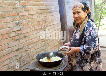 Déjeuner de riz frit avec la famille Uighour, Turpan, région autonome du Xinjiang, Chine. Banque D'Images