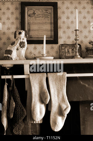 Chaussettes tricotées main accroché sur vintage mantlepiece pour sécher Banque D'Images