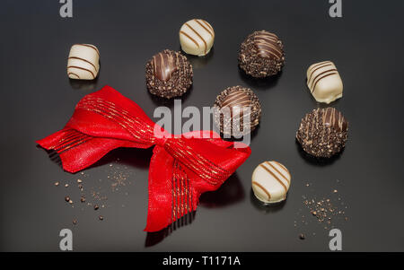 Truffes Pralines en chocolat et rouge ruban attaché. Décoration de fête de Noël. Banque D'Images