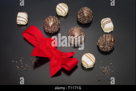 4pièce et blanc 4cfp. brown truffes au chocolat et décoratif arc rouge. Banque D'Images