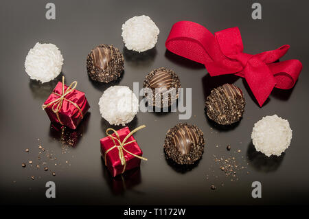 Variation des pralines en chocolat aux noisettes et noix de coco balls pour le jour de Noël avec red bow liée. Deux petits carrés de Noël fort. Ambiance festive decorati Banque D'Images