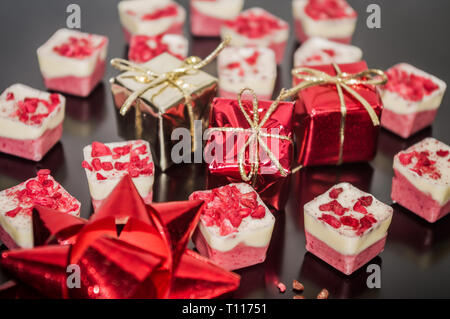 Chocolat sur fond de table avec décoration de vacances festives avec ruban rouge attaché. Banque D'Images