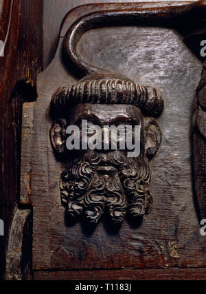 Tête d'un barbu, mature & tonsured moine ou clerc sur un misericord des stalles en chêne dans le choeur de l'église paroissiale de Beaumaris, Anglesey, Pays de Galles Banque D'Images