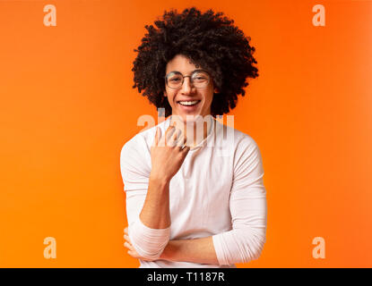 Carefree Cute guy noirs frisés rire sur fond orange Banque D'Images
